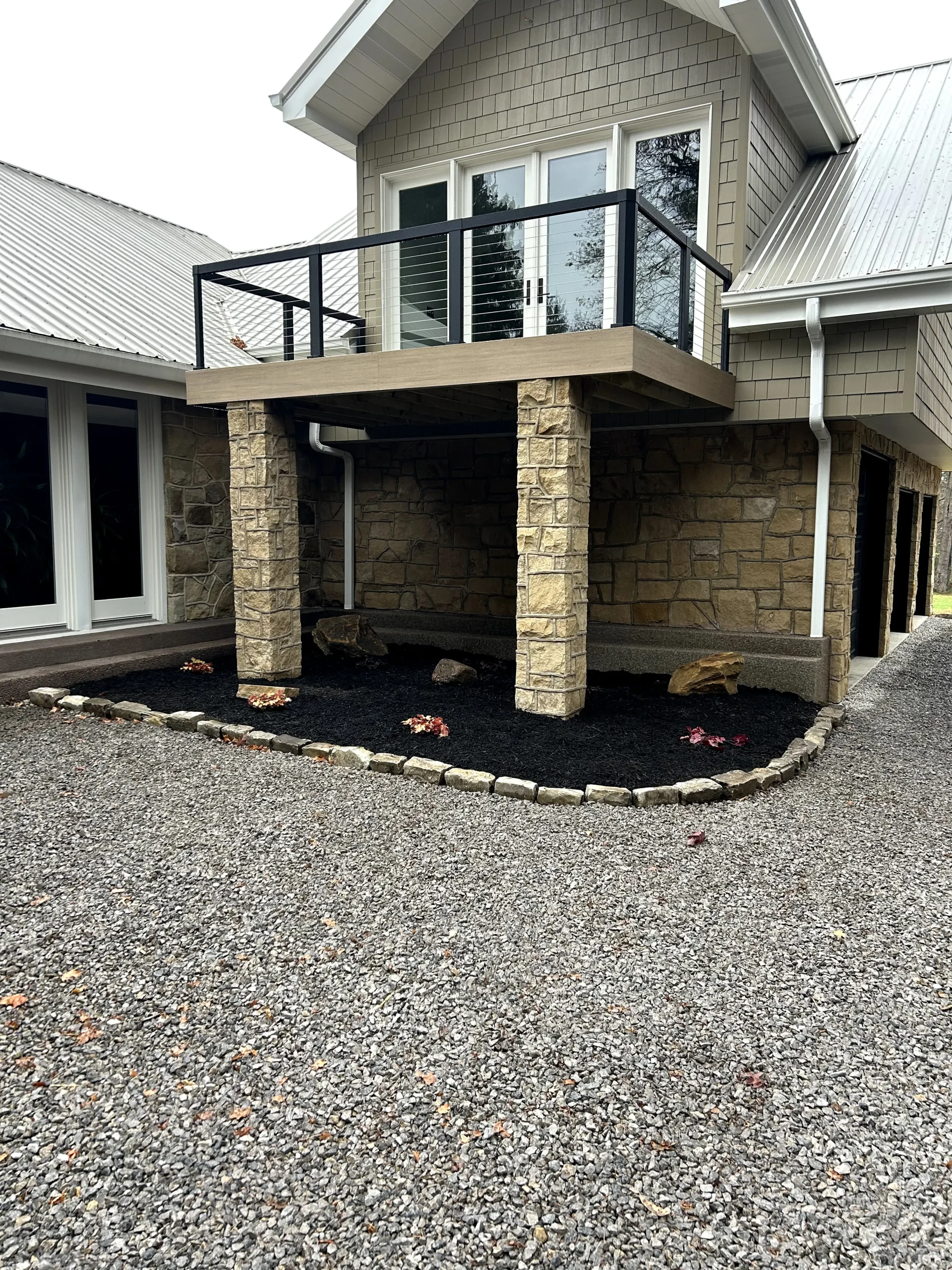 Cobble Stone Bordered Mulch Bed Underneath Balcony