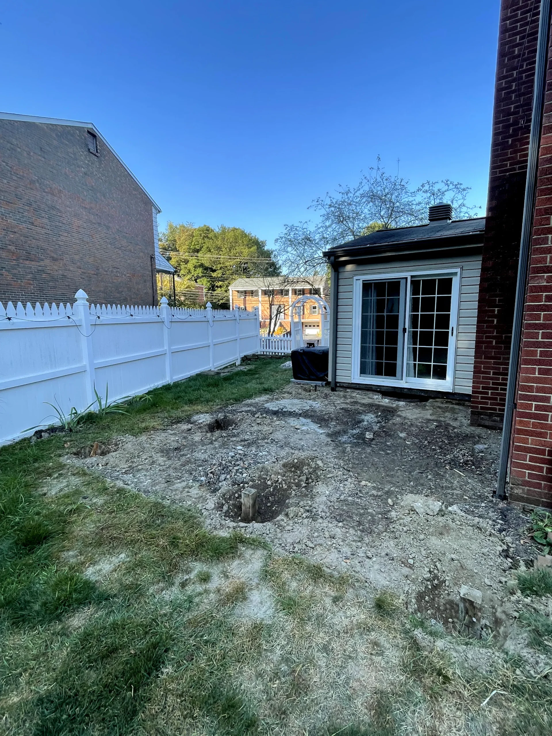 Before photo of torn up yard before paver patio installation